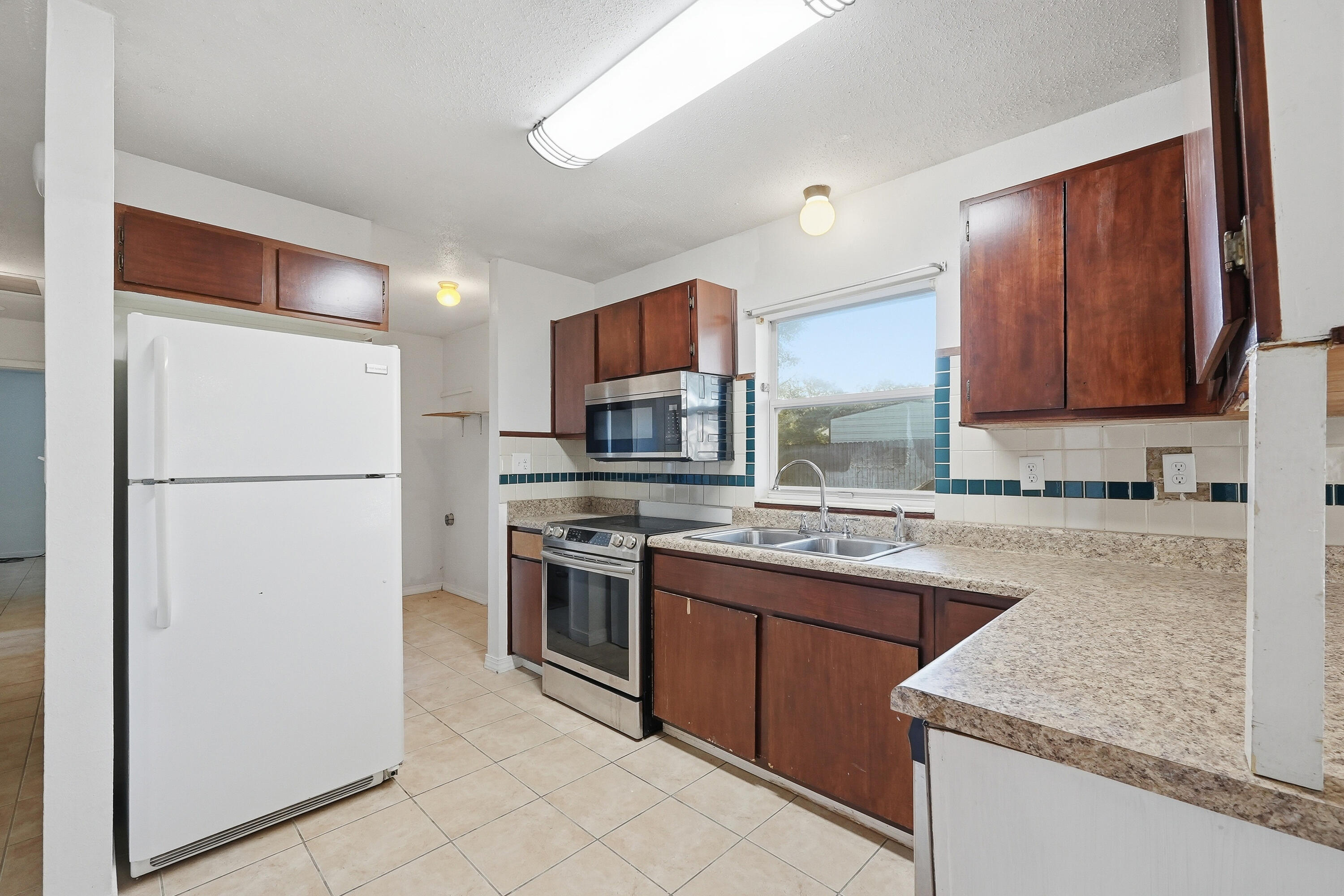 63 Oak Lane Shalimar, FL 32579 - Photo 14 of 42 a kitchen with stainless steel appliances granite countertop a refrigerator stove a sink and a microwave