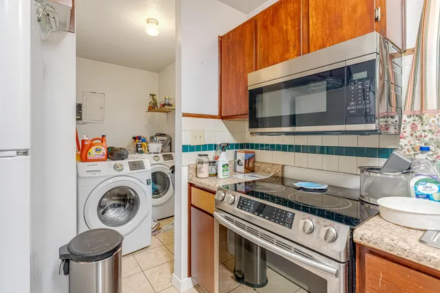 a kitchen with lots of appliances a sink cabinets and a window