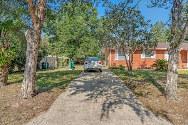 a front view of a house with a yard and an trees