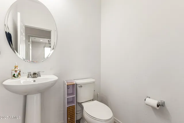 a white toilet sitting next to a bathroom sink