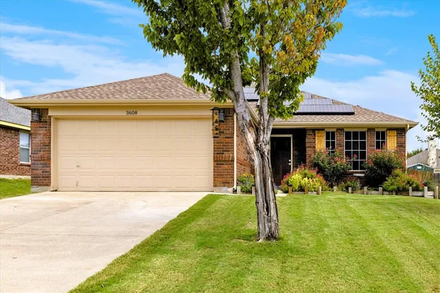 a front view of a house with yard and green space