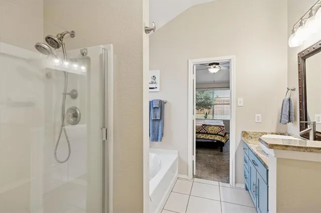 a en suite bathroom with a granite countertop sink a mirror and shower