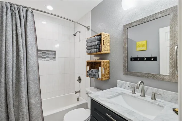 a bathroom with a granite countertop sink toilet and shower