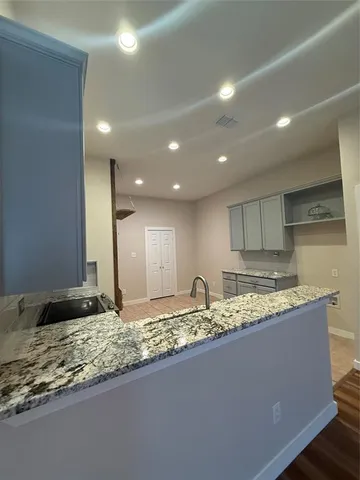 a bathroom with a granite countertop sink and a large mirror