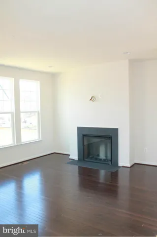 an empty room with wooden floor and fireplace