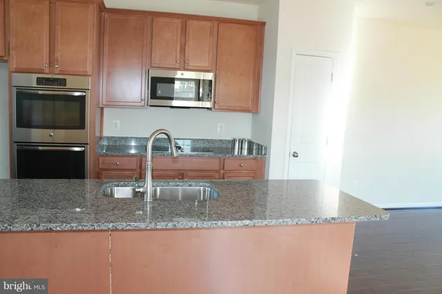 a kitchen with granite countertop a sink and a stove top oven with granite countertops