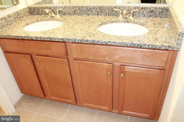 a bathroom with a granite countertop sink and a mirror