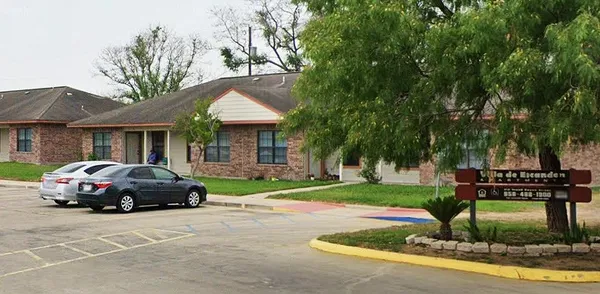a car parked in front of a house next to a yard