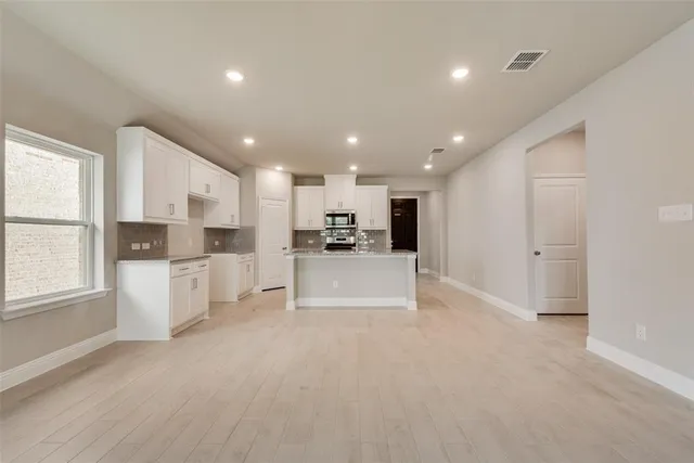 a view of kitchen with kitchen island white cabinets and refrigerator