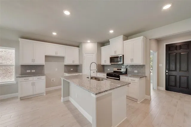 a kitchen with white cabinets appliances and sink