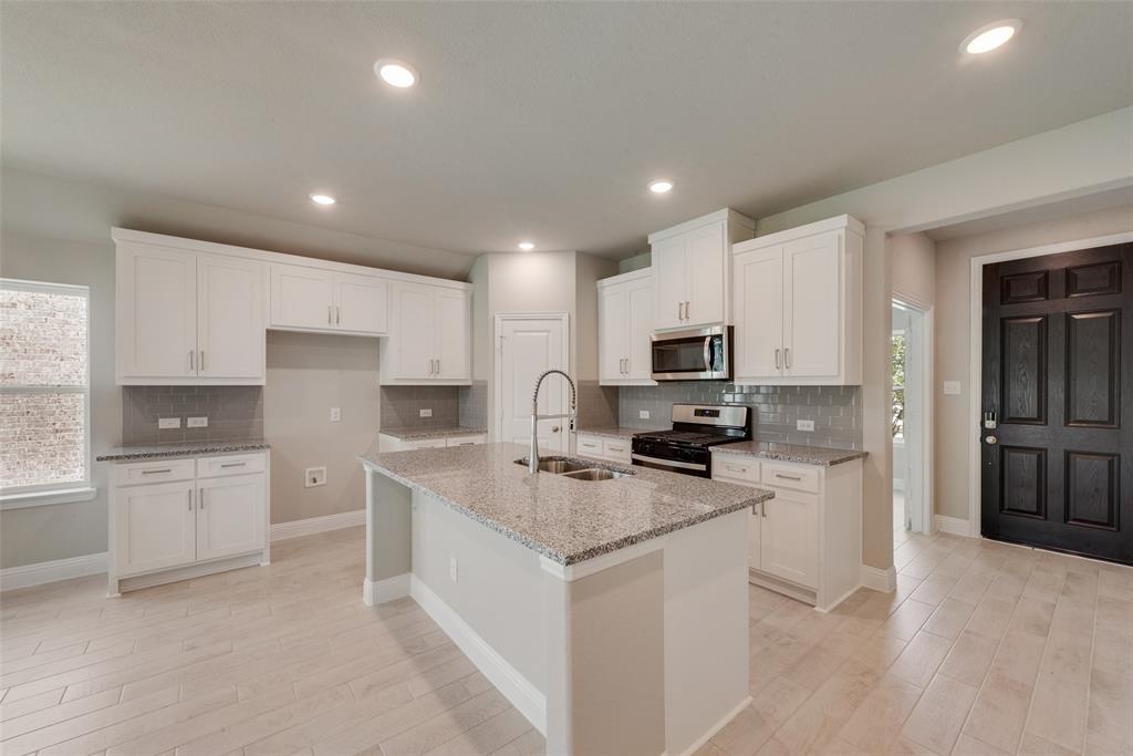 3206 Ferrero Lane Princeton, TX 75407 - Photo 8 of 29 a kitchen with white cabinets appliances and sink