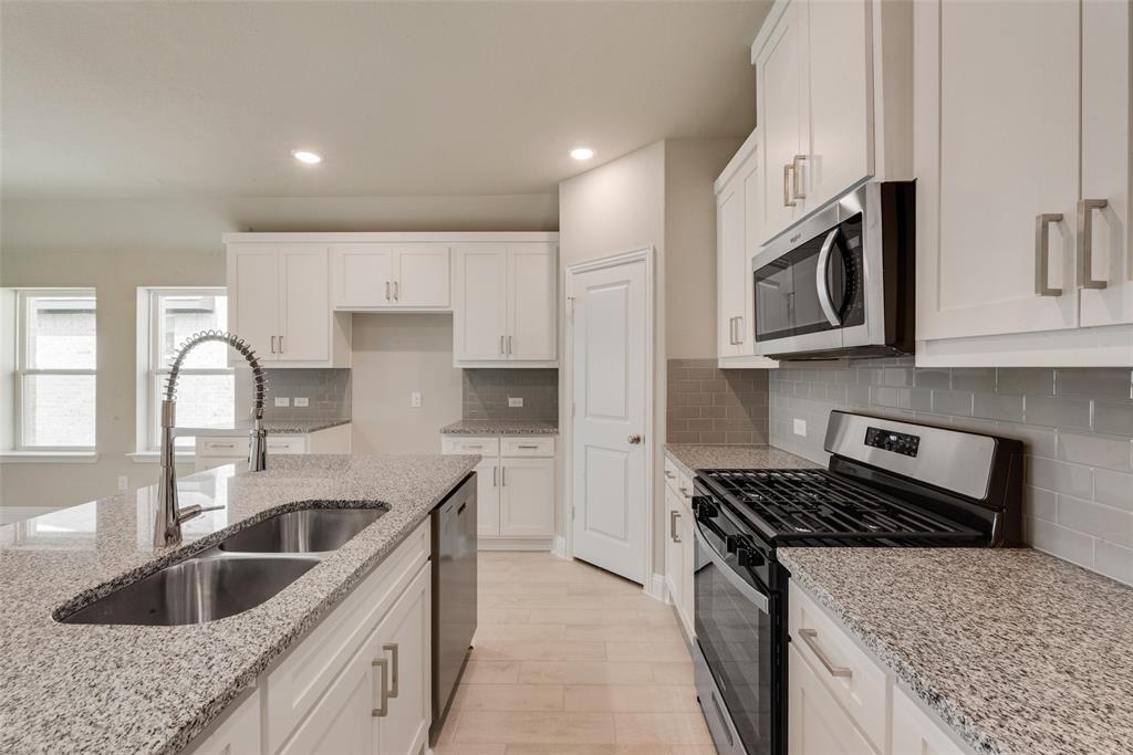 3206 Ferrero Lane Princeton, TX 75407 - Photo 9 of 29 a kitchen with stainless steel appliances granite countertop a sink and stove