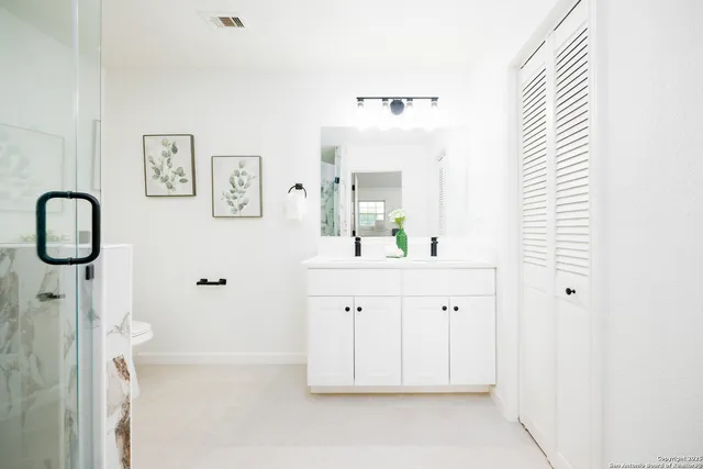 a spacious bathroom with a double vanity sink and a mirror