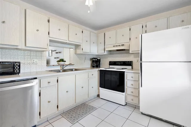 a kitchen with cabinets stainless steel appliances and sink