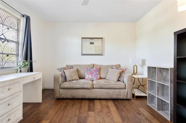a living room with a couch and a dresser with wooden floor