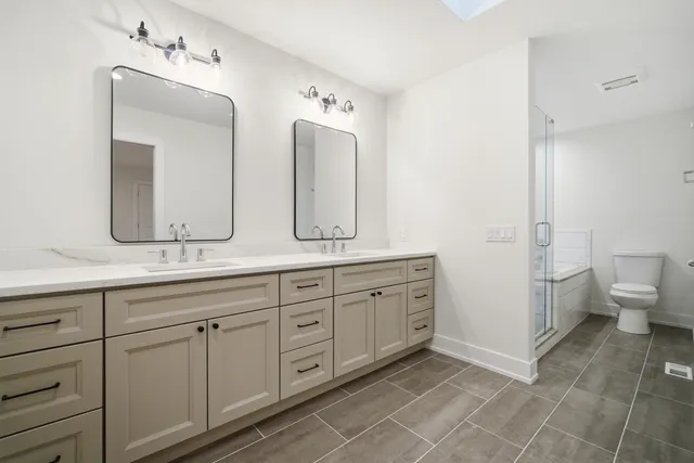 a spacious bathroom with double sink and a mirror
