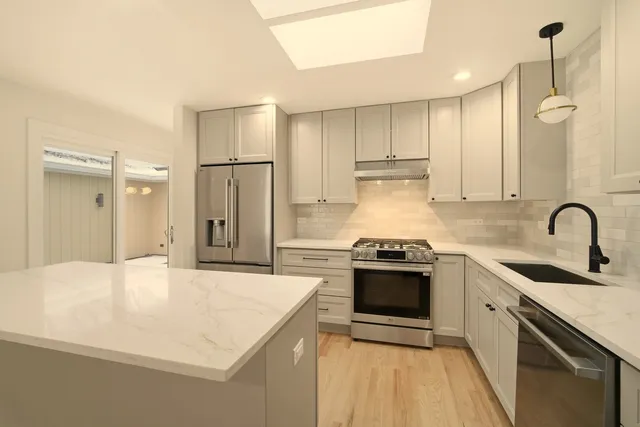 a kitchen with a sink stainless steel appliances and cabinets