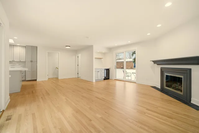a view of an empty room with a fireplace and a window