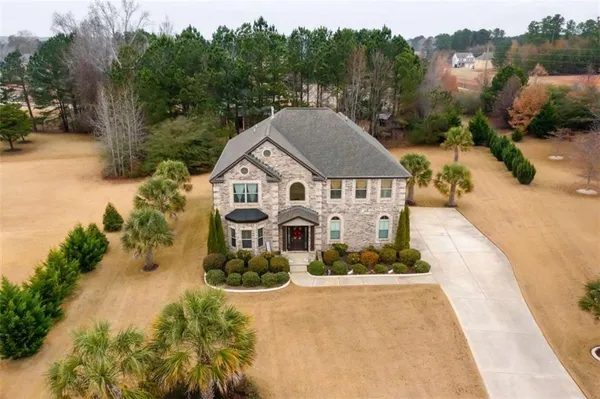 an aerial view of a house with yard and green space