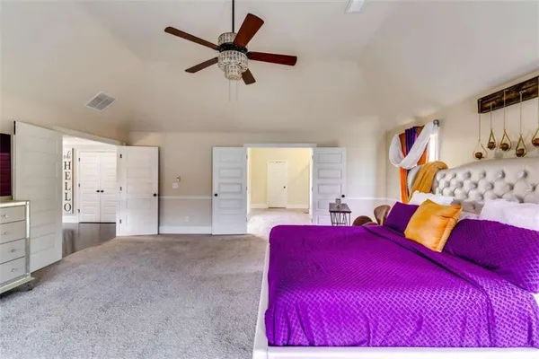 a bedroom with a large bed and a chandelier