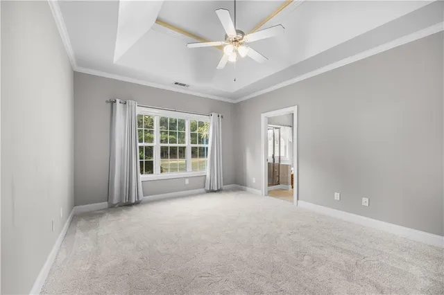 an empty room with windows and ceiling fan