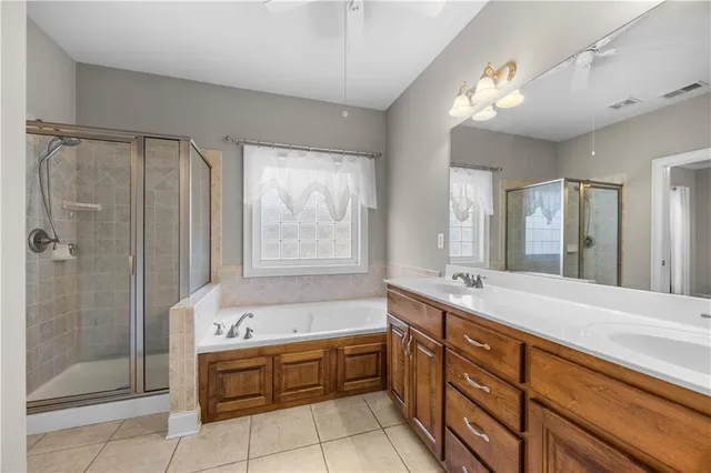 a spacious bathroom with a tub sink shower and mirror