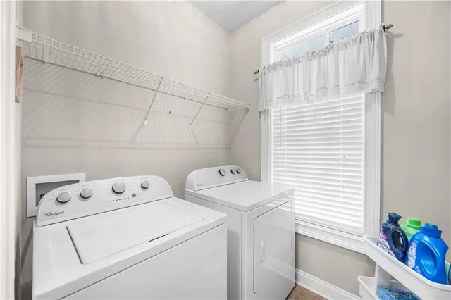 a view of washer and dryer with bathroom in the background