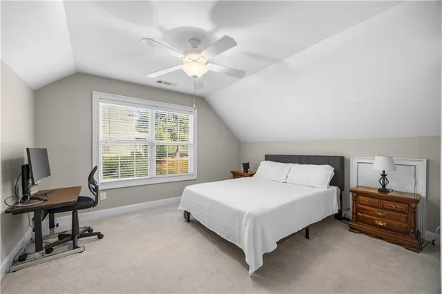 a bedroom with a bed flat screen tv and a large window
