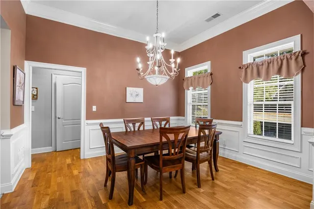 a dining room with furniture a chandelier and wooden floor