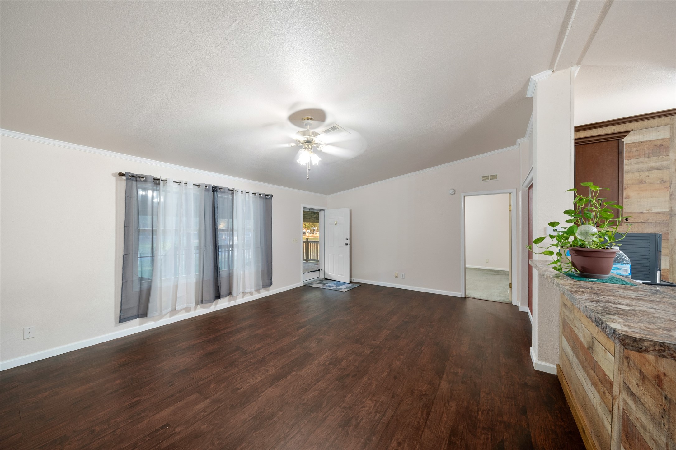 31351 Buckeye Road Waller, TX 77484 - Photo 9 of 36 a view of an empty room with wooden floor and a potted plant