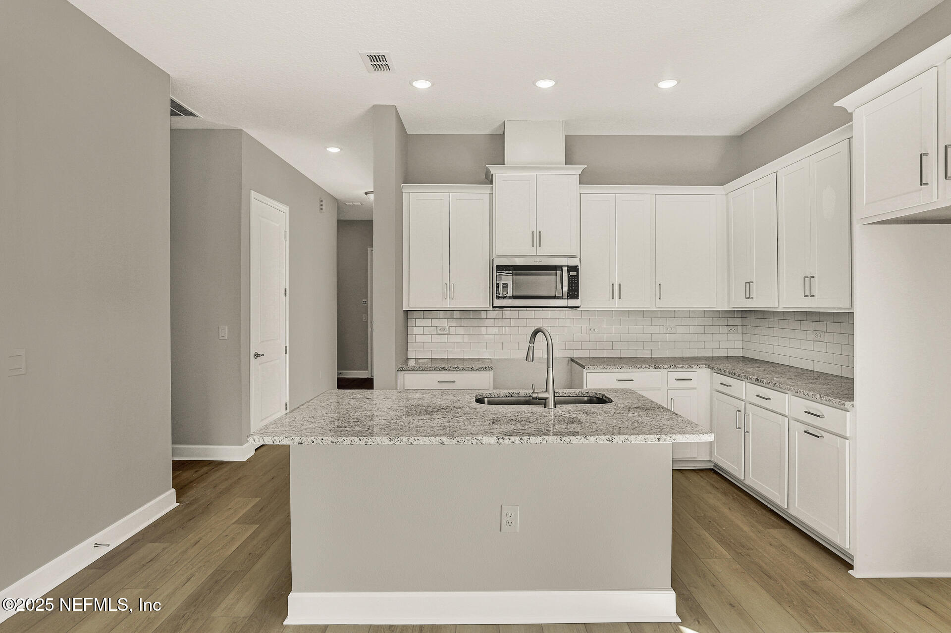 42 Tillia Trail St. Augustine, FL 32092 - Photo 11 of 18 a kitchen with kitchen island granite countertop white cabinets and white appliances