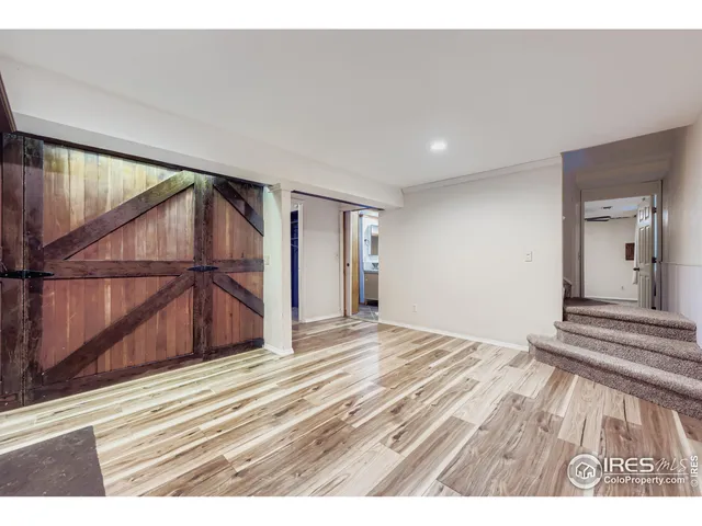 a view of a room with wooden floor and white walls