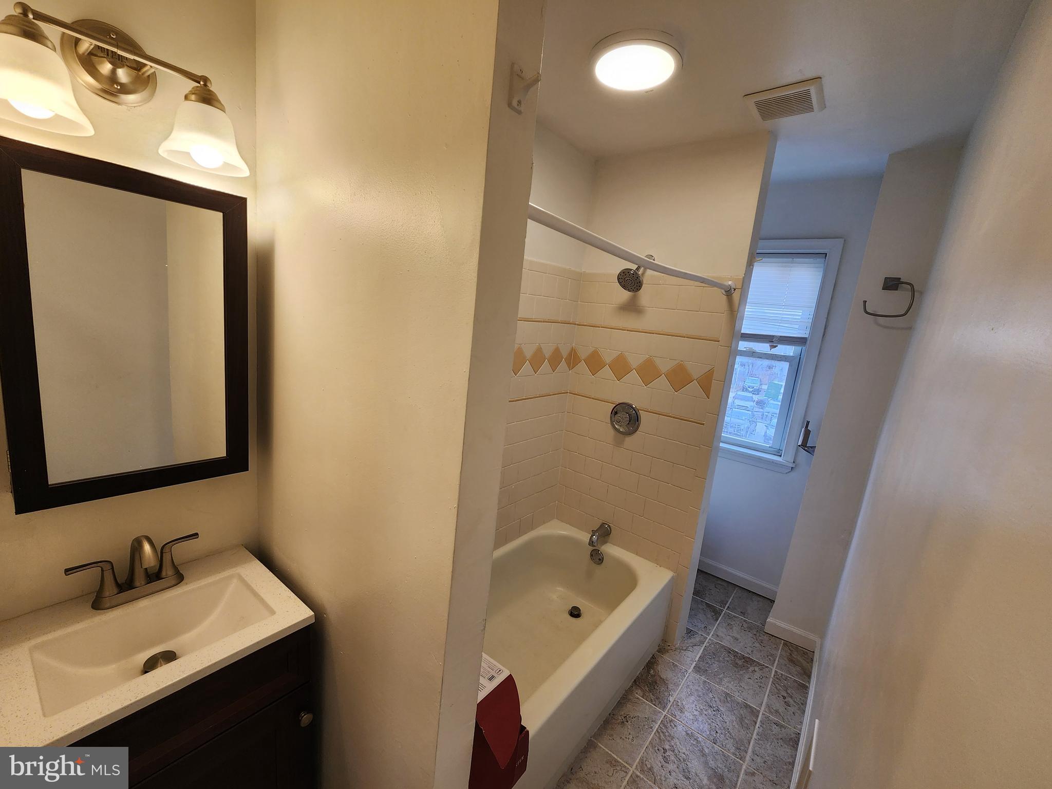 1213 East Lanvale Street Baltimore, MD 21202 - Photo 17 of 22 a bathroom with a tub sink and mirror