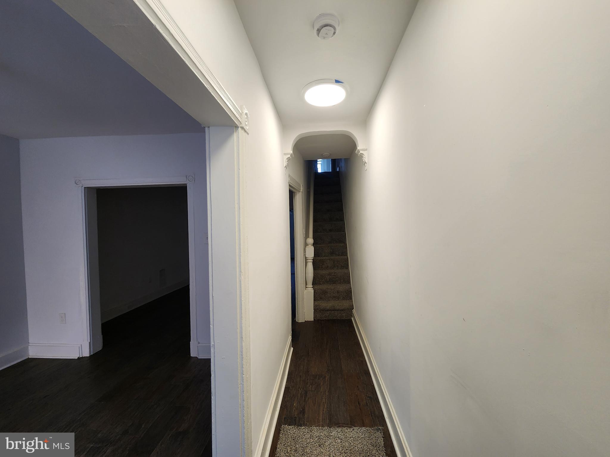 1213 East Lanvale Street Baltimore, MD 21202 - Photo 4 of 22 a view of a hallway with wooden floor and a bathroom
