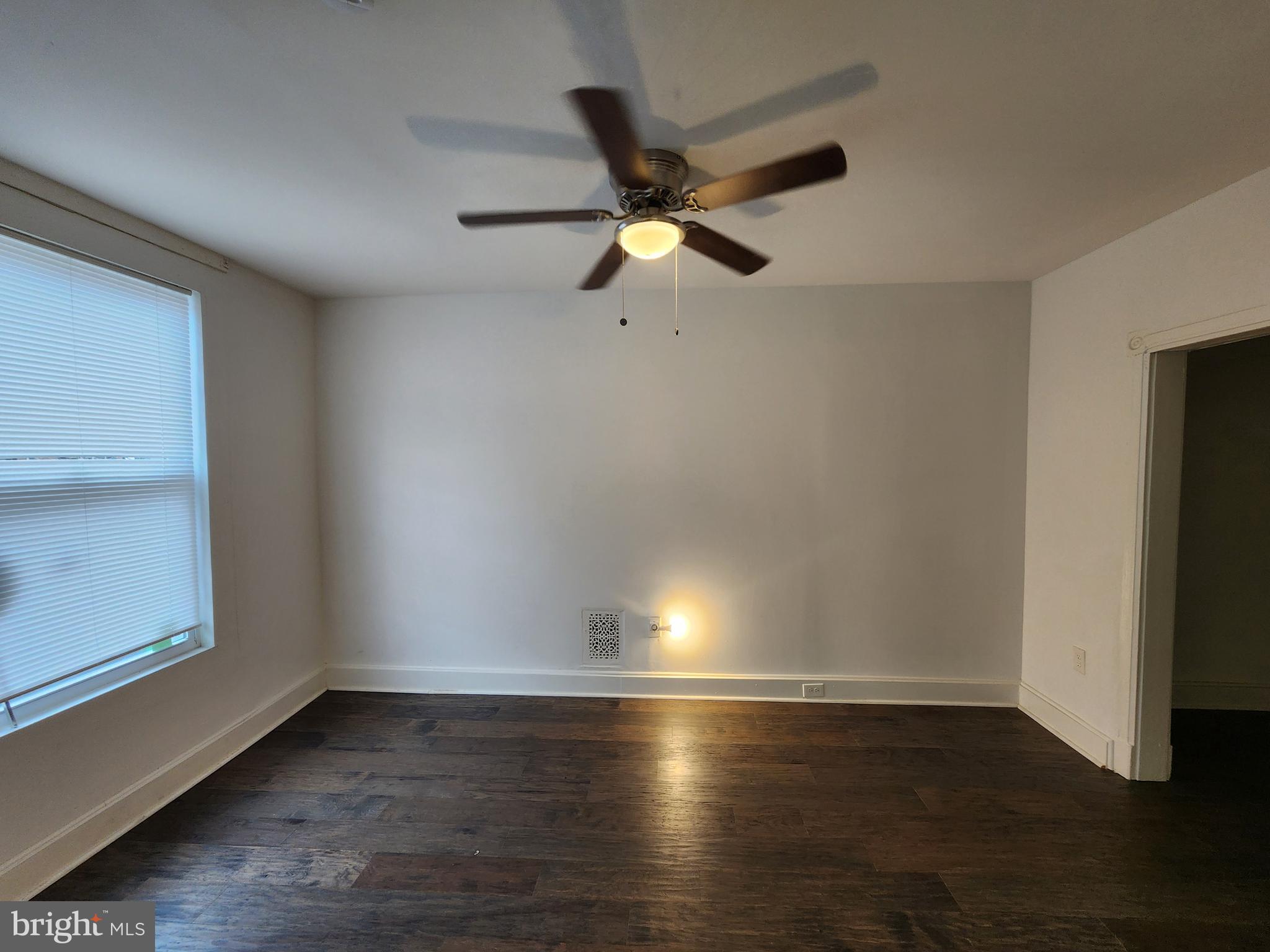 1213 East Lanvale Street Baltimore, MD 21202 - Photo 6 of 22 an empty room with wooden floor and windows
