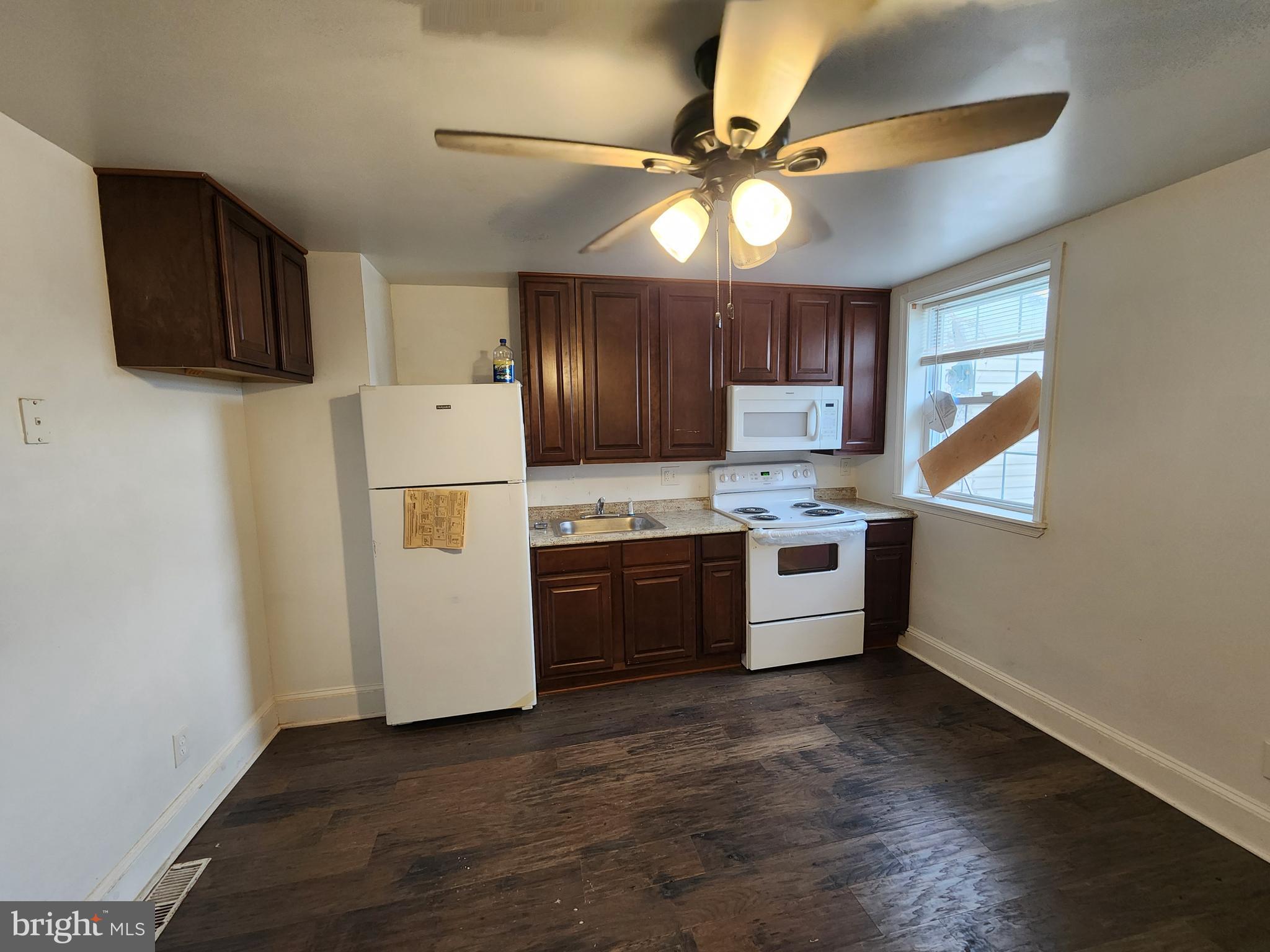 1213 East Lanvale Street Baltimore, MD 21202 - Photo 9 of 22 a kitchen with a stove a refrigerator and a microwave