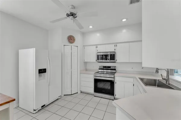 a kitchen with appliances a sink and cabinets
