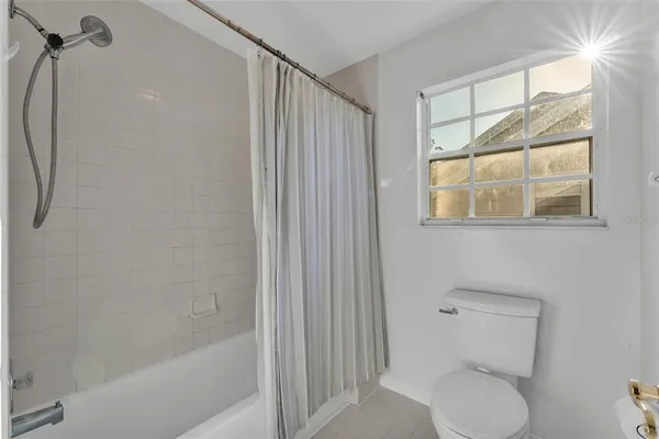 a view of a room with a fan and hardwood floor