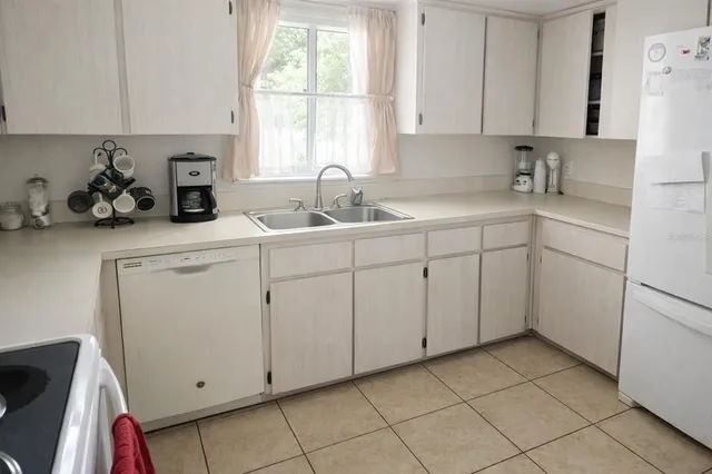a kitchen with white cabinets a sink and a window