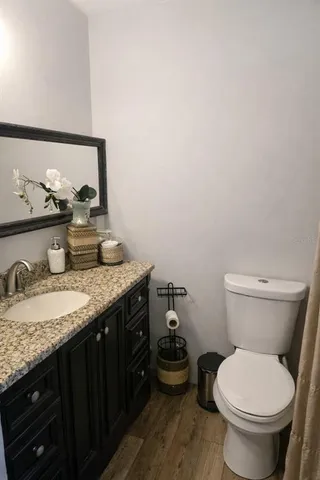 a bathroom with a granite countertop toilet sink and mirror