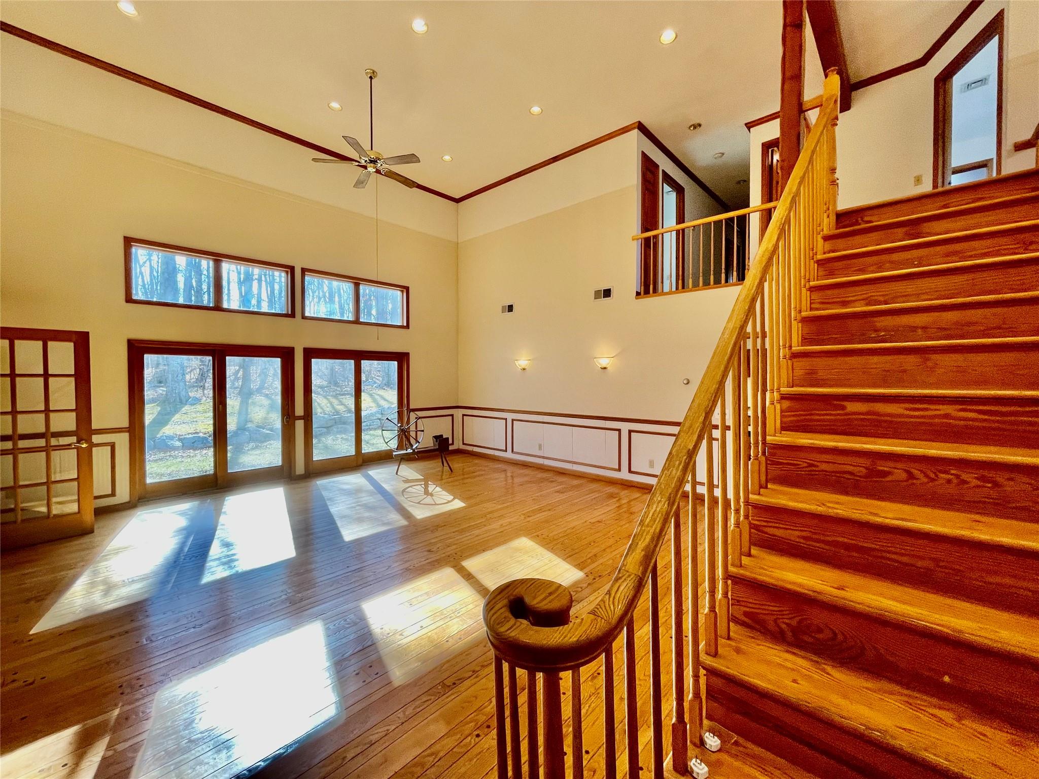 71 Saddleback Ridge Wallkill, NY 12589 - Photo 11 of 39 Stairway with a decorative wall, a towering ceiling, ceiling fan, wood finished floors, and wainscoting