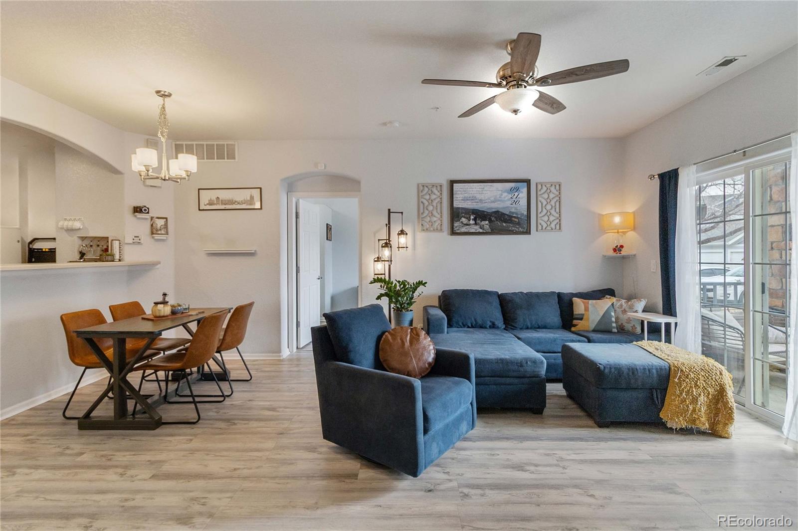 5255 Memphis Street, Unit 702 Denver, CO 80239 - Photo 2 of 30 a living room with furniture and a chandelier