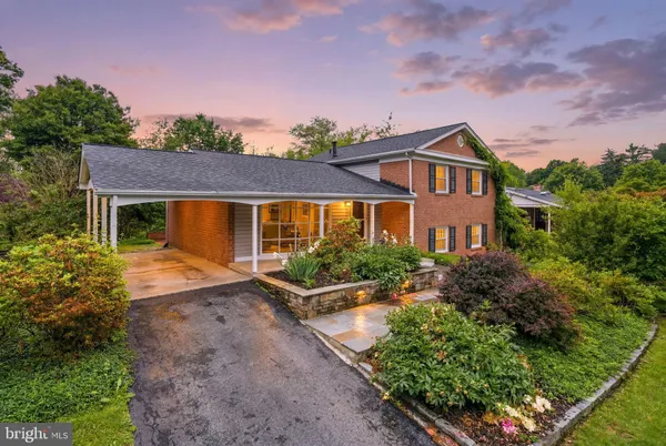 a front view of a house with a yard and potted plants