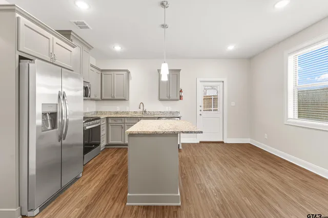 a kitchen with a refrigerator sink and cabinets