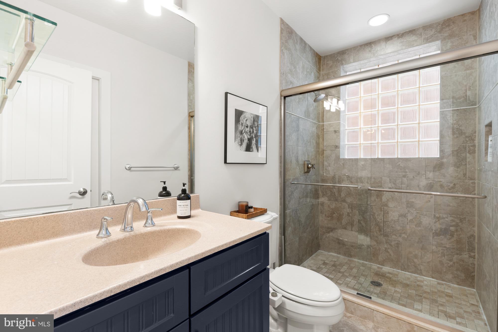 1464 Harvard Street Northwest, Unit 3 Washington, DC 20009 - Photo 23 of 24 a bathroom with a sink toilet a mirror and shower