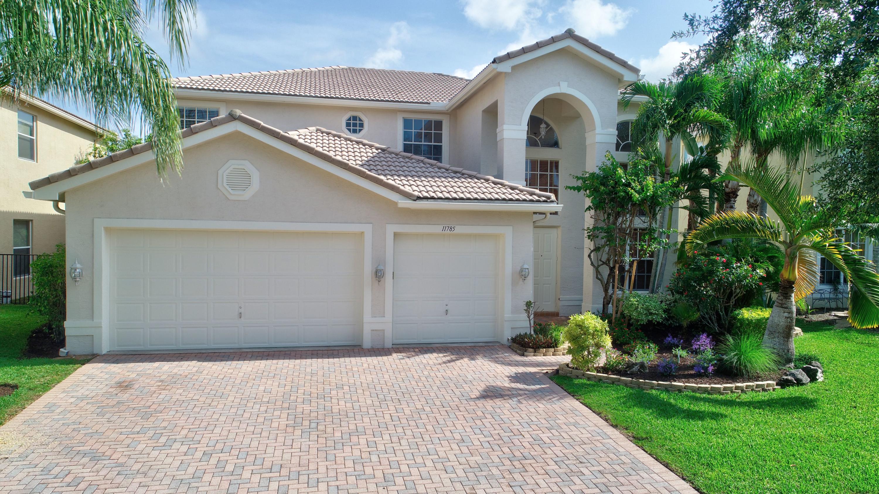 11785 Preservation Lane Boca Raton, FL 33498 - Photo 2 of 53 a front view of a house with a garden and plants