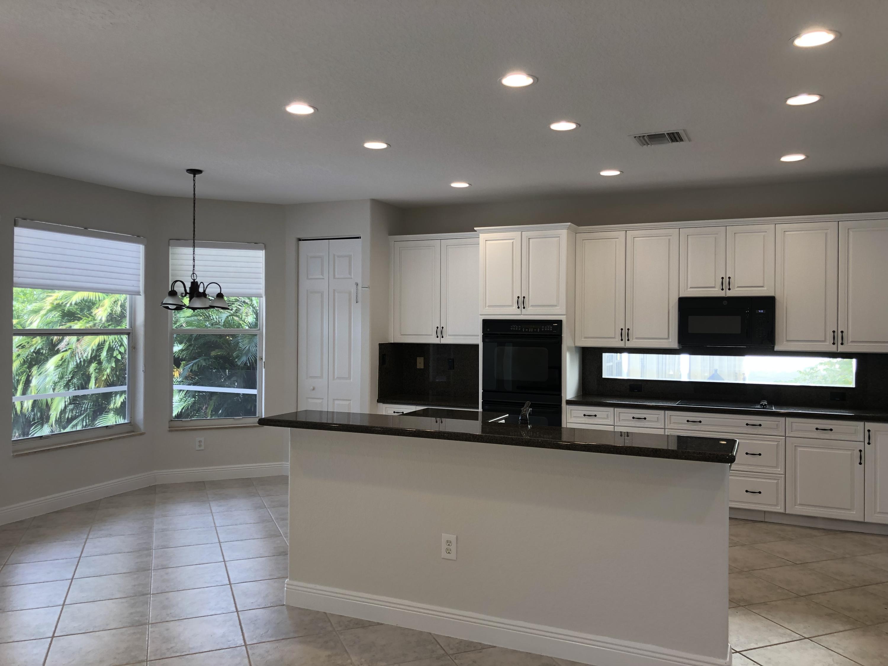 11785 Preservation Lane Boca Raton, FL 33498 - Photo 9 of 53 a kitchen with stainless steel appliances a microwave a sink and a stove top oven