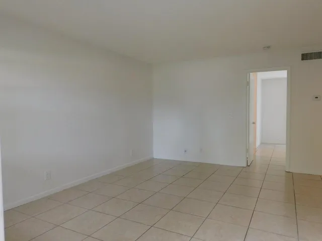 an empty room with white walls and tiles