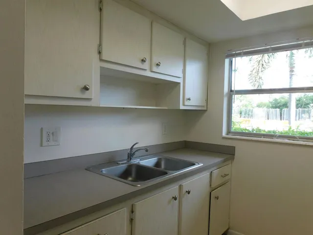 a kitchen with a refrigerator sink and cabinets