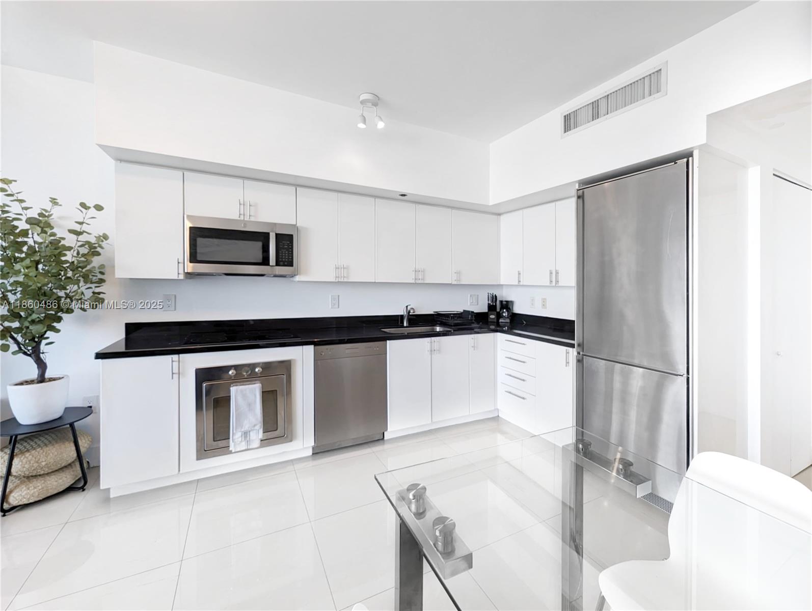92 Southwest 3rd Street, Unit 1908 Miami, FL 33130 - Photo 4 of 18 a kitchen with a refrigerator and a stove top oven